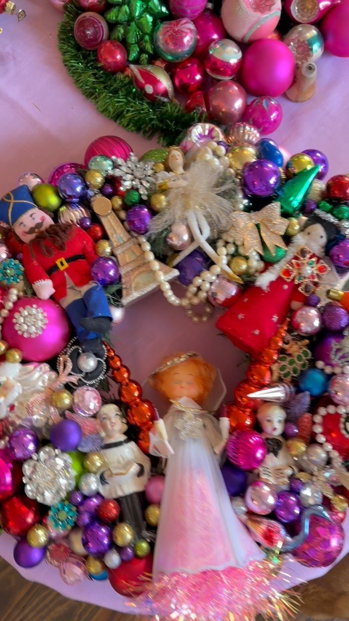 Colorful vintage Christmas wreath with ornaments, a nutcracker, and a small doll.