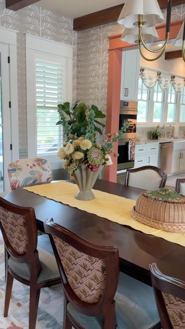 Dining room with a dark wood table and chairs featuring mixed fabric patterns.
