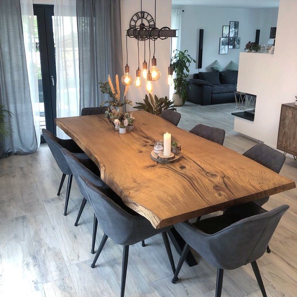 Live-edge wooden dining table with grey chairs in a modern open-concept living room