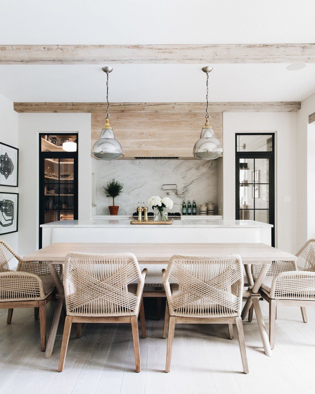 Light wood dining table with woven rattan chairs in a bright, modern boho room