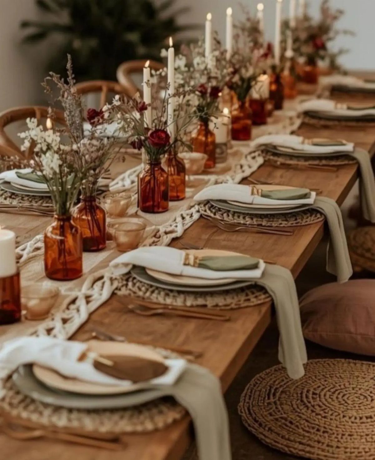 Wooden dining table with a white macrame runner, amber vases, and woven placemats.