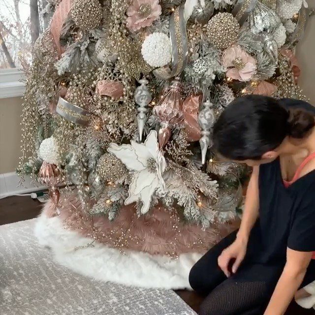 White faux fur tree skirt at the base of a decorated Christmas tree.