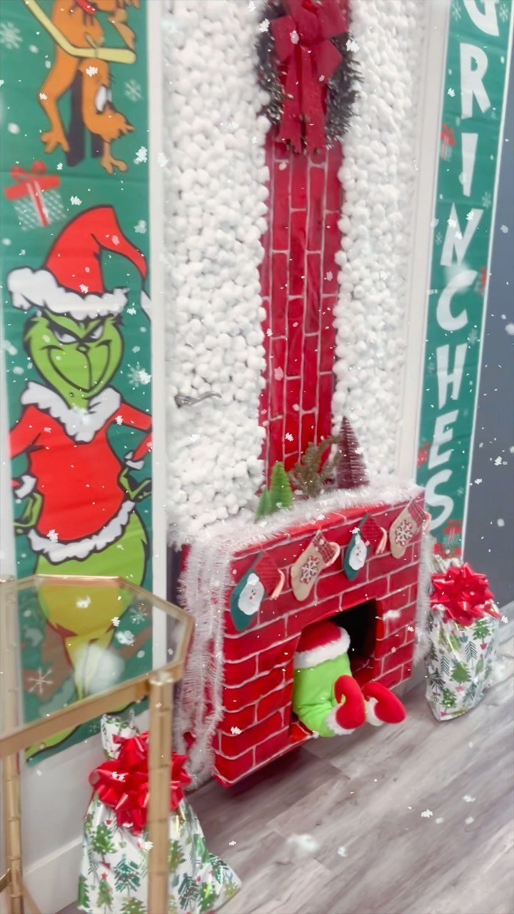 Decorated office door featuring a red brick fireplace with the Grinch peeking out.