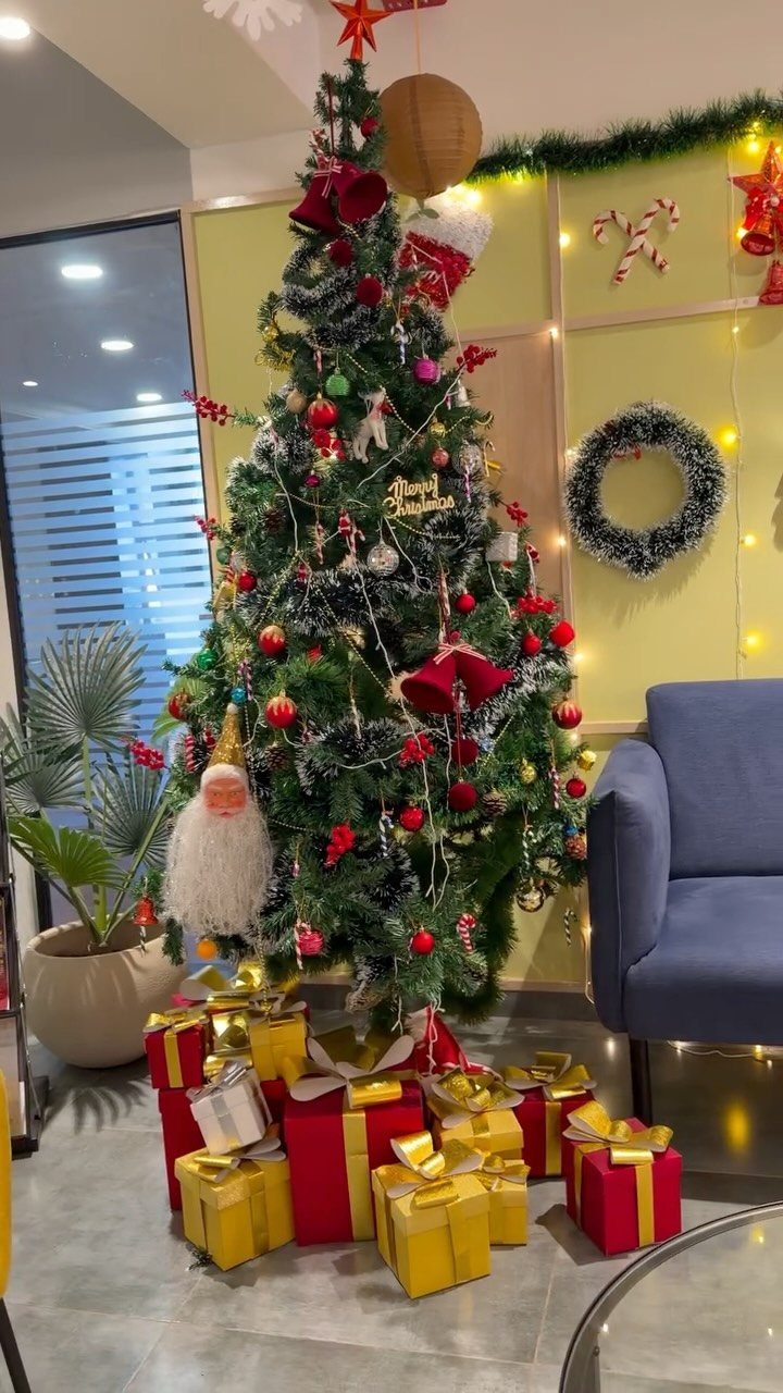 Decorated Christmas tree with red and gold gifts in a modern office lounge