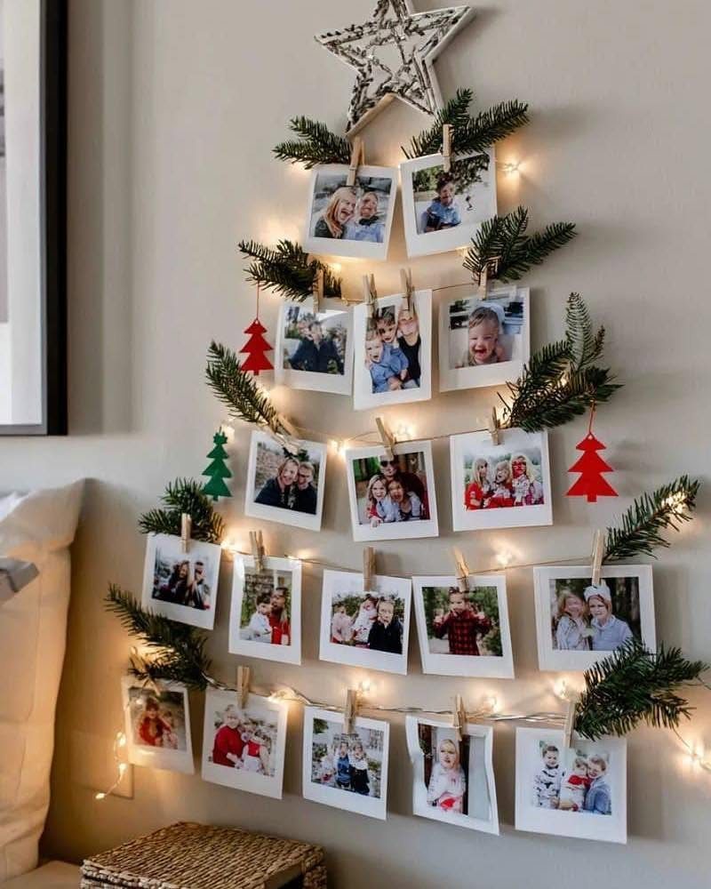 Wall-mounted Christmas tree made of string lights, pine branches, and family photos.