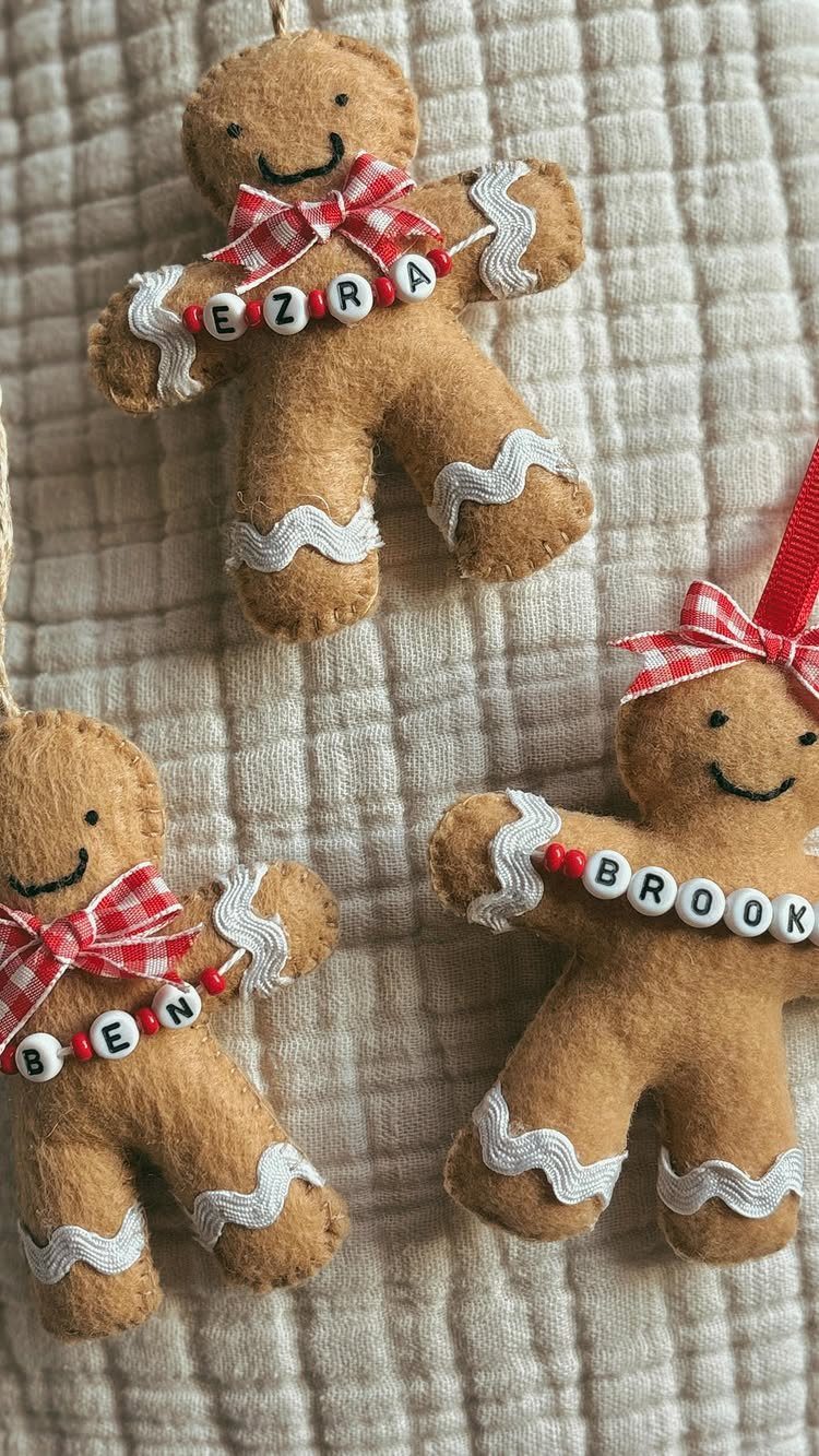 Three felt gingerbread man ornaments with personalized name beads and red checkered bows.
