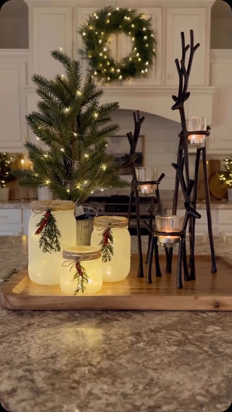 Frosted mason jars with fairy lights and greenery on a wooden tray