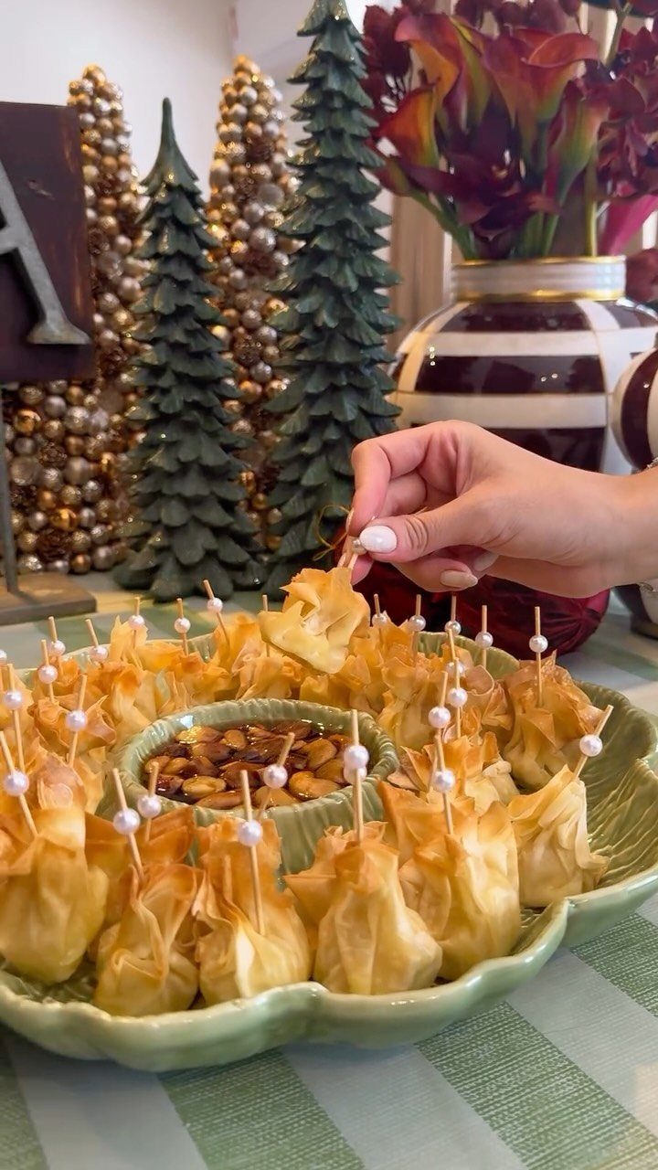 Golden-brown pastry bites on a green platter with festive Christmas decorations in background
