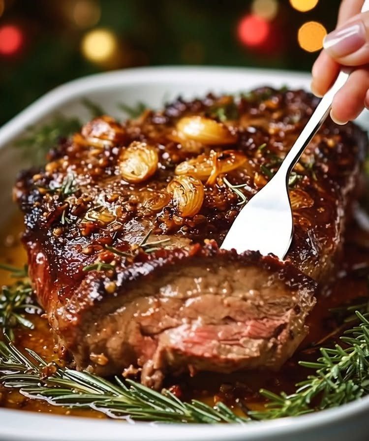 Herb-crusted rib roast with roasted garlic and rosemary in a white serving dish.