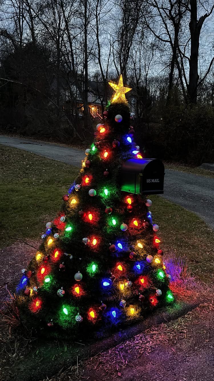 Mailbox decorated as a Christmas tree with colorful lights and a star topper.
