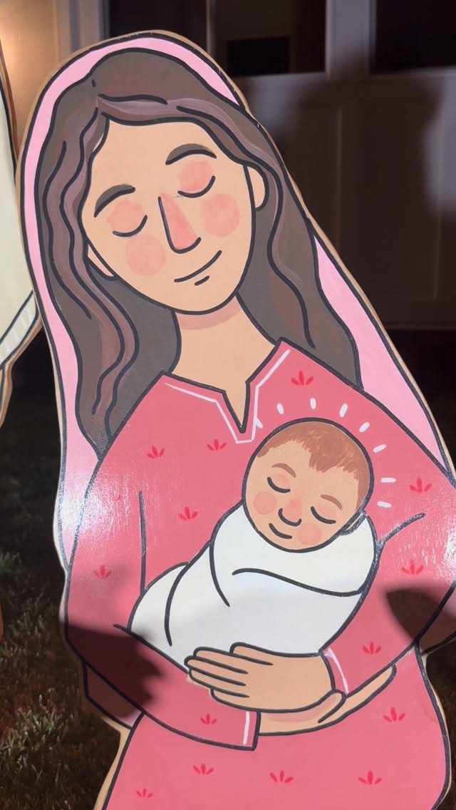 Wooden cutout of Mary holding baby Jesus as a Christmas yard decoration