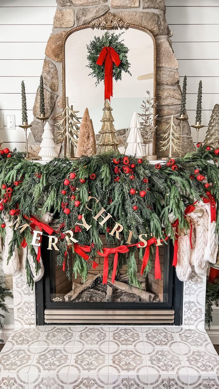 Fireplace mantel decorated with evergreen garland, red ornaments, and a Merry Christmas banner.