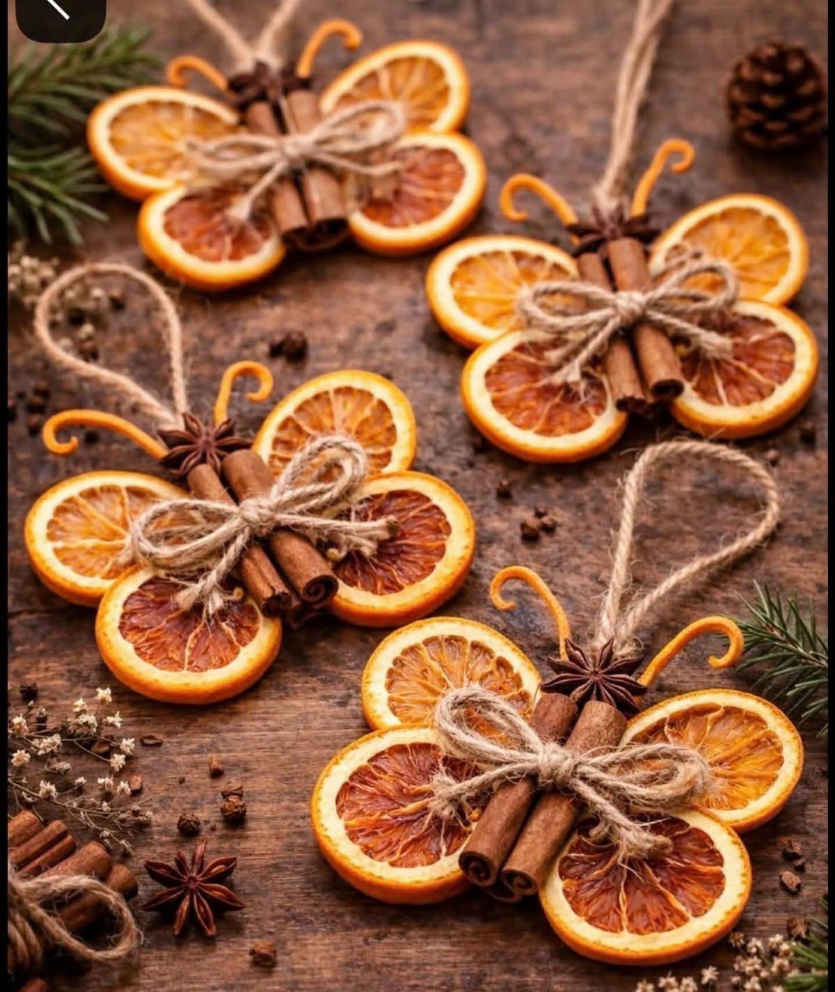 Dried orange slice ornaments with cinnamon sticks and star anise on wooden background