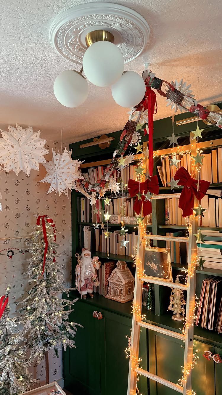 Festive Christmas decorations including a flocked tree and a decorated green bookshelf.