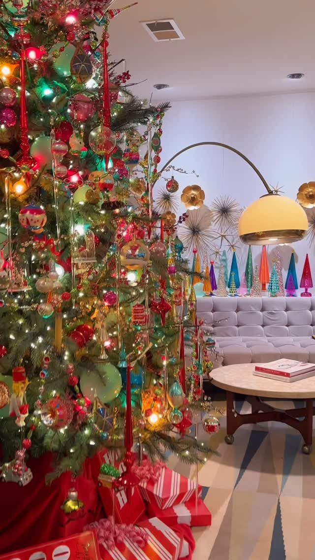 Decorated Christmas tree in a mid-century modern living room with a yellow arc lamp.