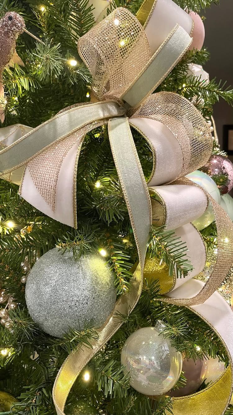 Gold and cream layered ribbons tied in a bow on a decorated Christmas tree