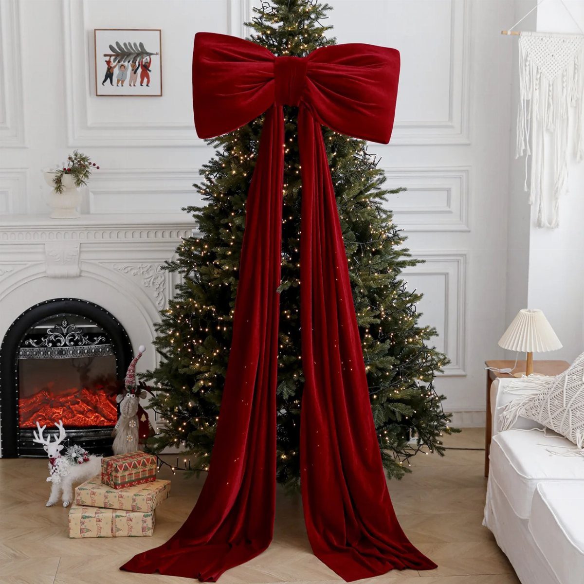 Large red velvet bow and long ribbons cascading down a lit Christmas tree