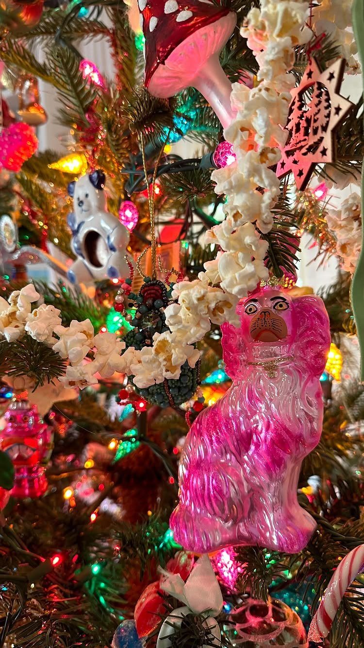 Popcorn garland draped over a Christmas tree with colorful lights and quirky ornaments.