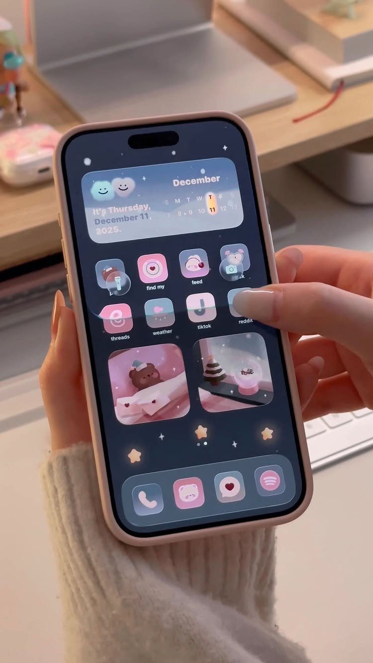 Smartphone screen showing a cute pink and blue December themed wallpaper and icons.
