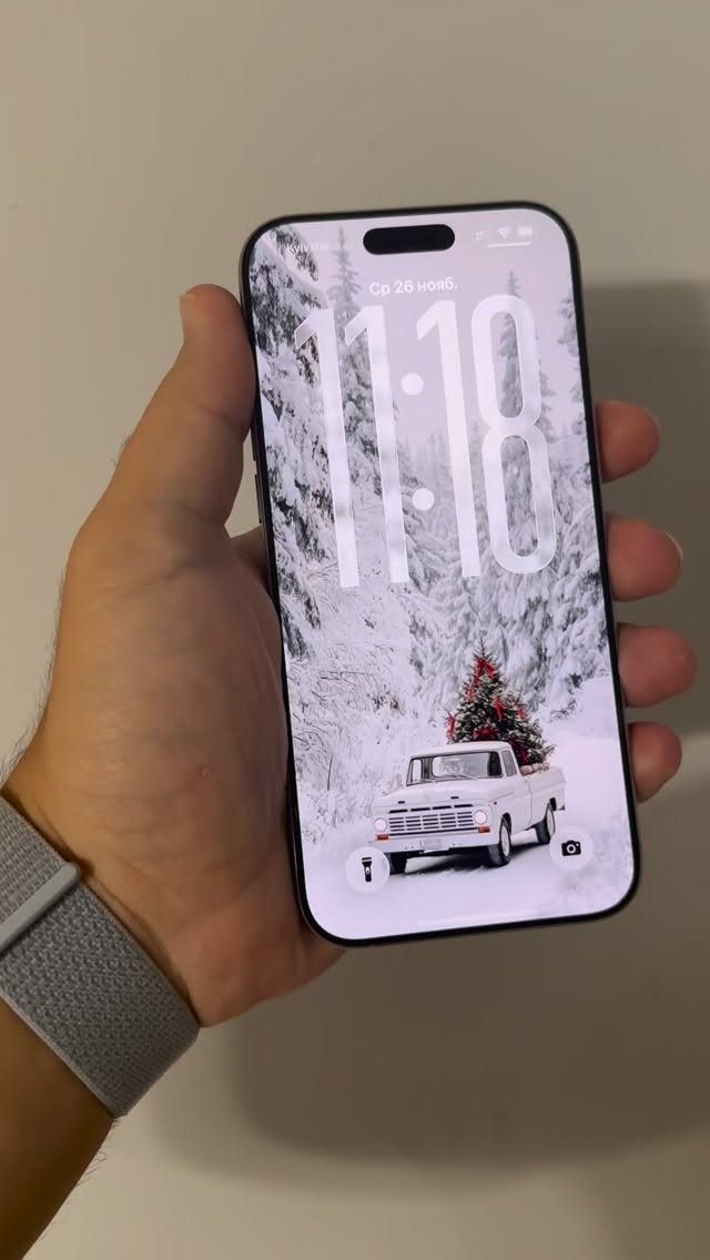 Smartphone screen showing a cute Christmas wallpaper with a truck and snowy trees