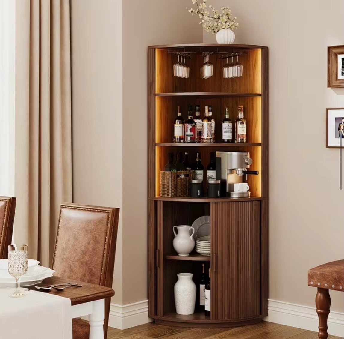 Curved wooden corner bar cabinet with lighting, bottles, and coffee machine in dining room