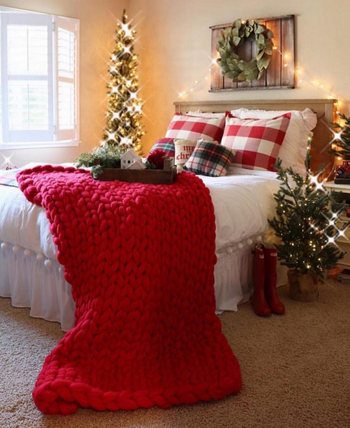 Red chunky knit blanket draped over a white bed in a Christmas bedroom
