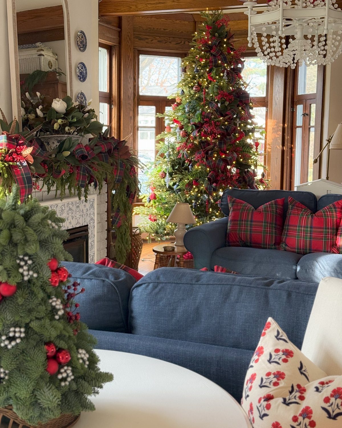 Blue sofa with red plaid pillows in a Christmas decorated living room