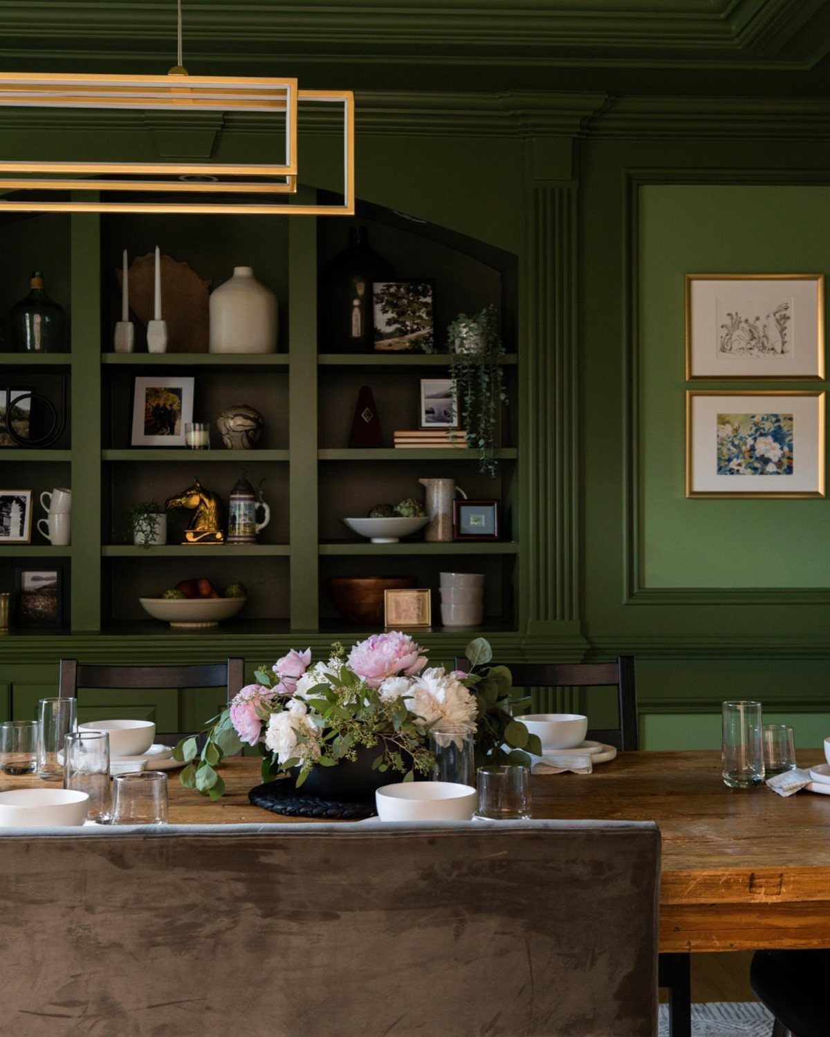 Dark green dining room with matching green ceiling, trim, and built-in shelving.