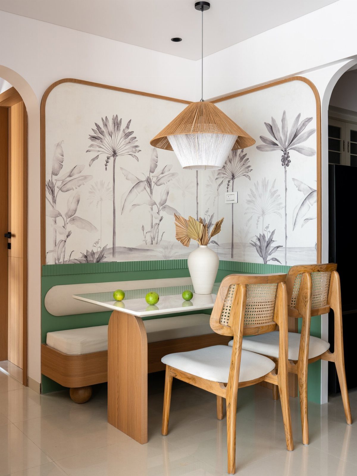 Built-in wooden dining bench with high white backrest and botanical wall mural.