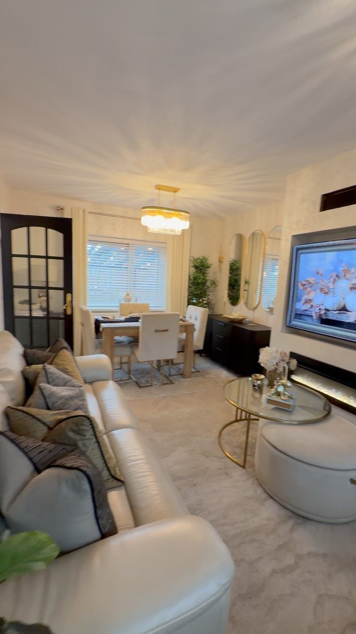 Open concept living area with a white leather sofa and dining set background.