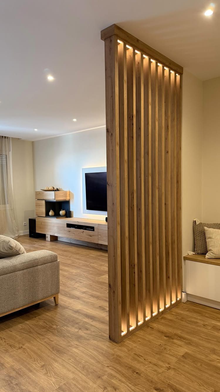 Wooden slat room divider separating a modern living room with a grey sofa.