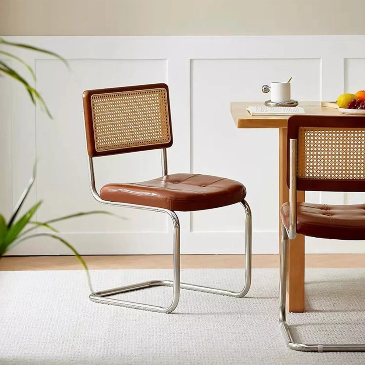 Armless dining chairs with brown leather seats and cane backs around a wooden table.
