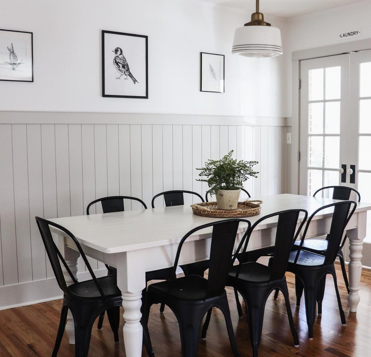 White beadboard wainscoting with a chair rail in a bright dining room.