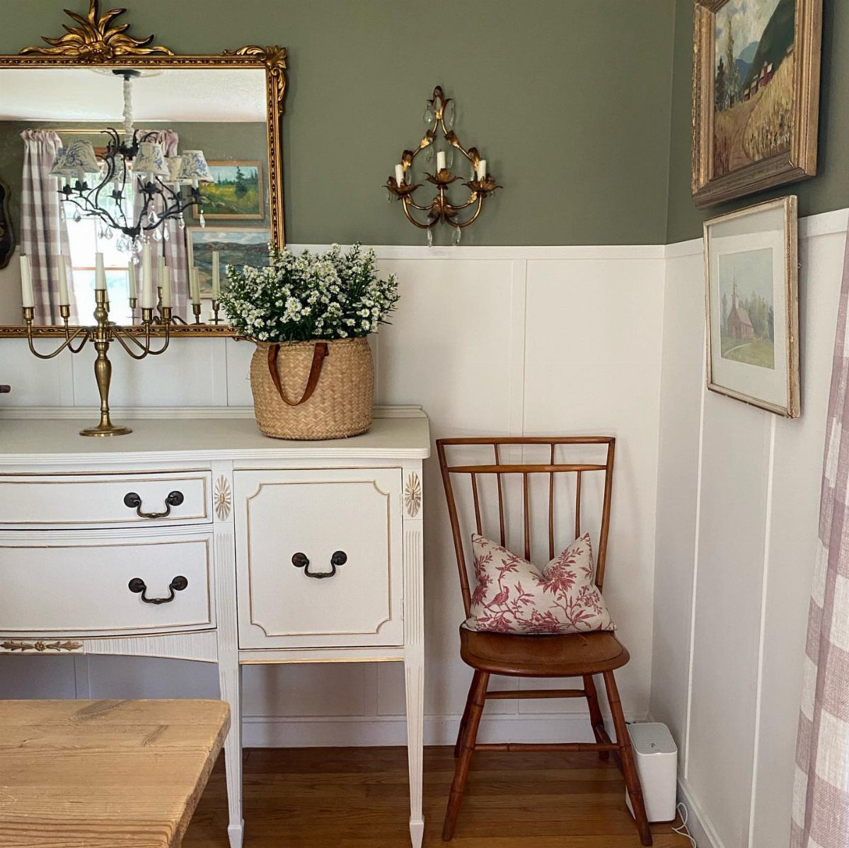 White chair rail separating olive green and white walls in a dining area.