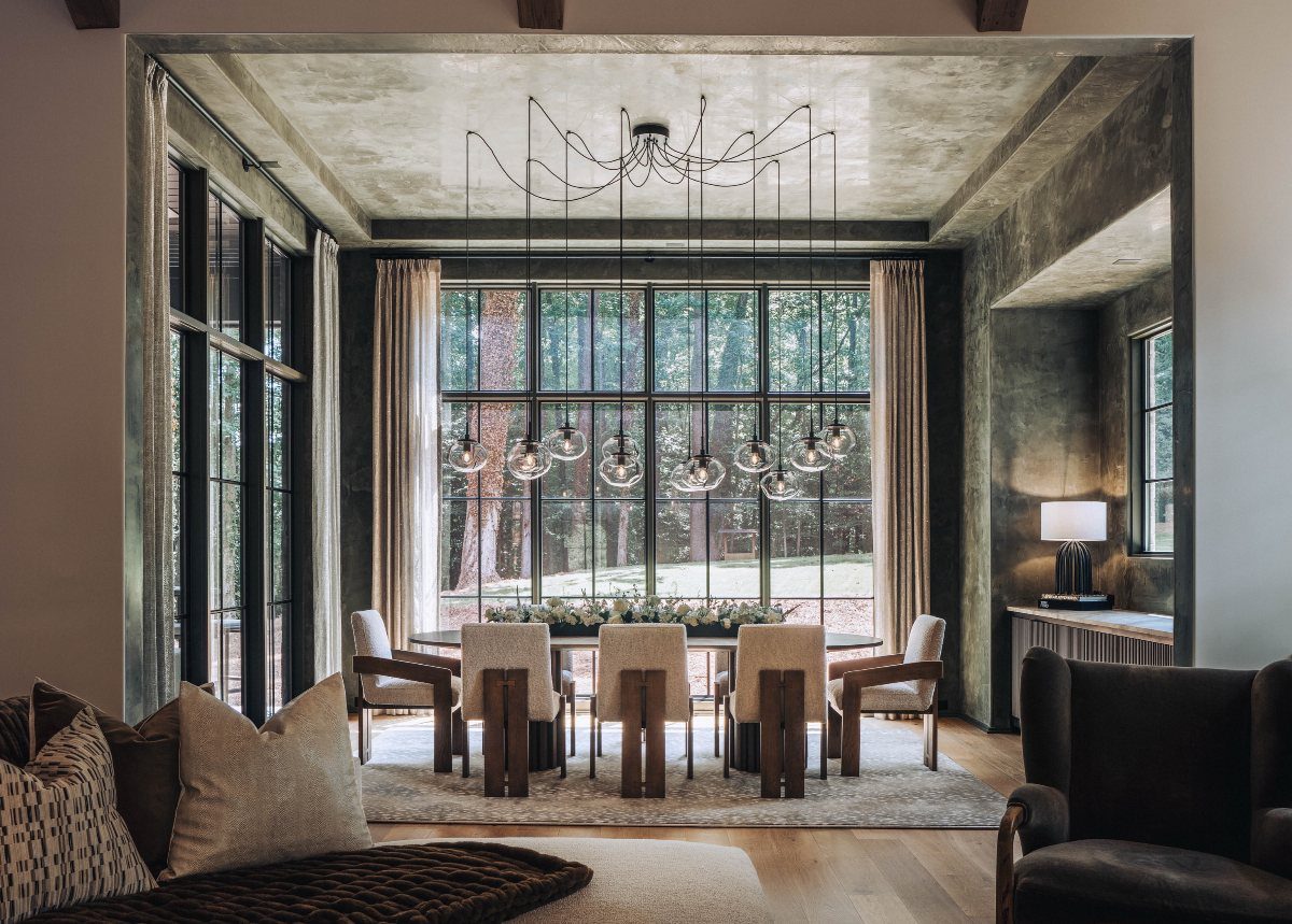 Modern dining room with a long wooden table and hanging glass globe pendant lights.
