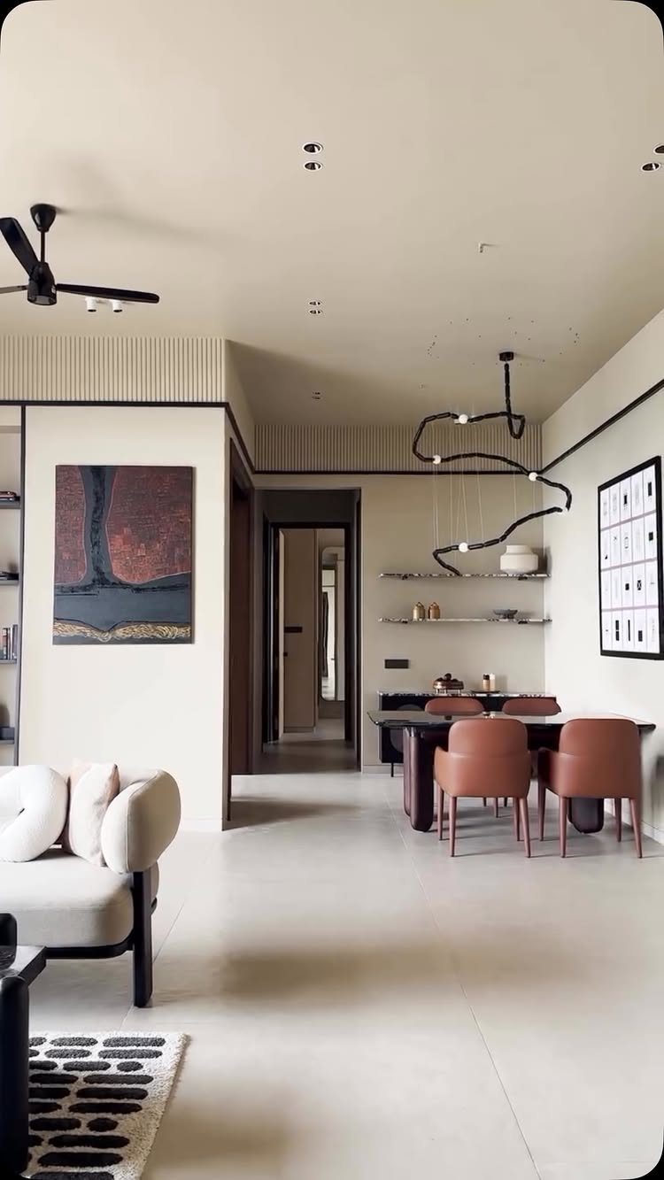 Modern dining area with terracotta chairs, dark table, and sculptural black ceiling lamp.