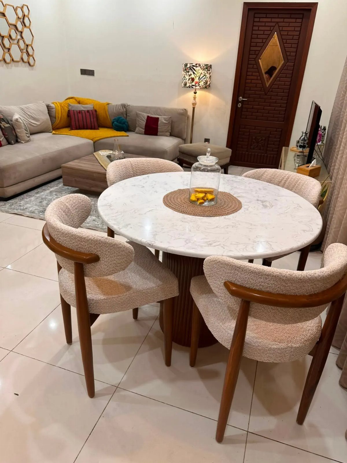 Round white marble dining table and beige chairs in an open-concept living room