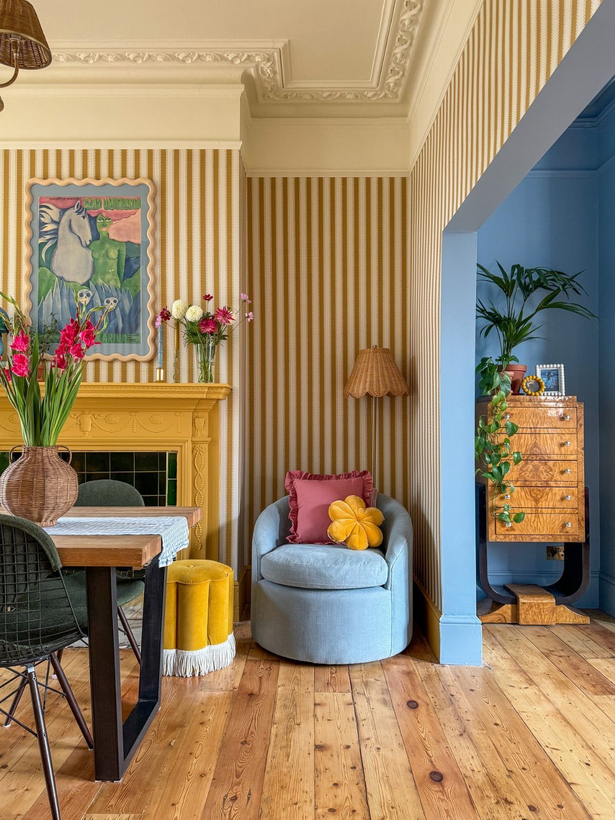 Yellow striped wallpaper and a blue accent wall in a colorful dining area.