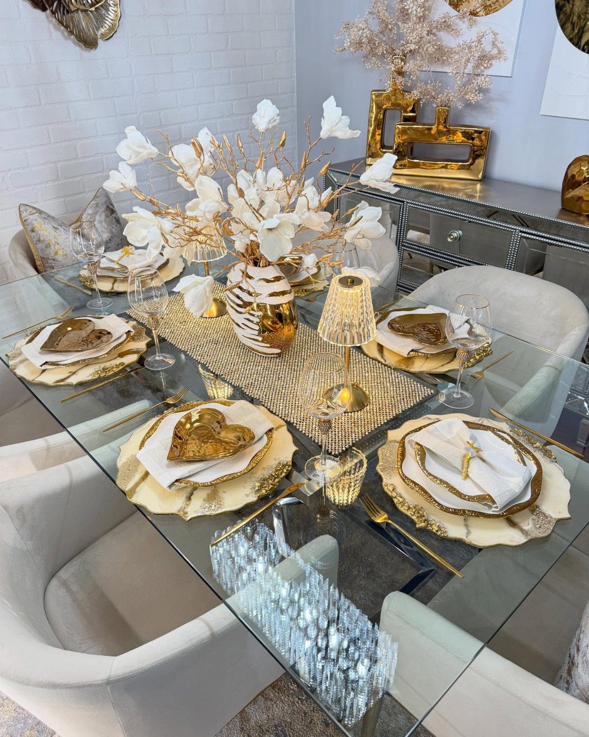 Gold and white sculptural vase with blossoms on a luxury dining table setting