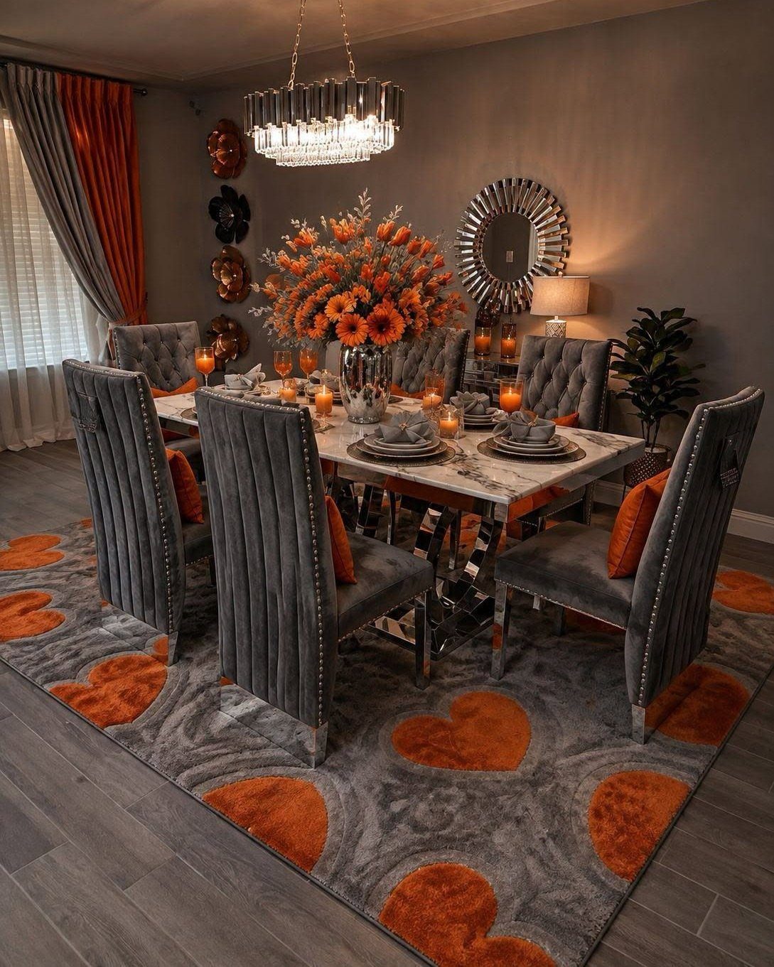 Grey and orange heart-patterned rug under a marble dining table with velvet chairs.
