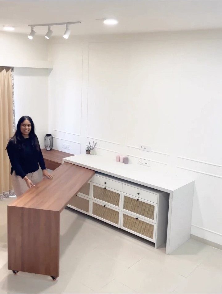 Woman standing by a white sideboard with a brown wooden pull-out extension table.