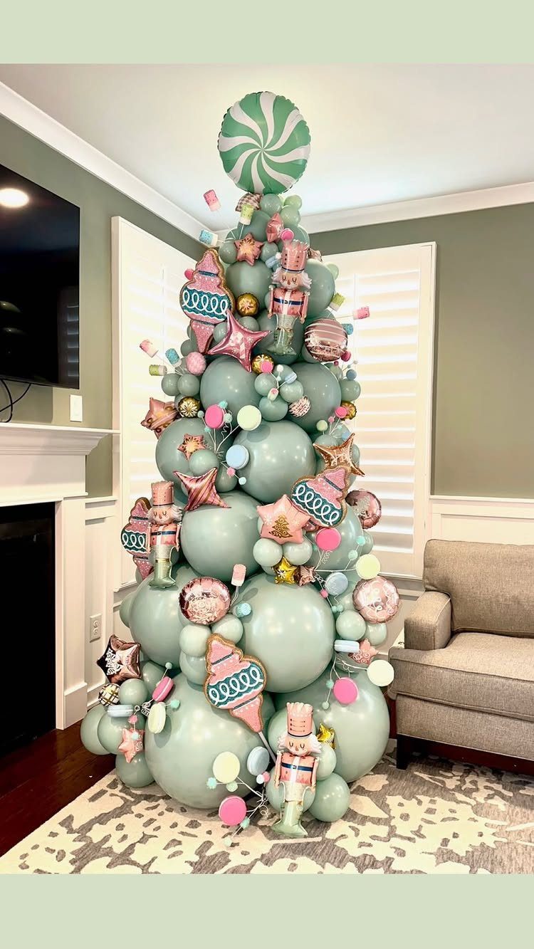 Balloon Christmas tree made of light green balloons with pink and gold decorations.