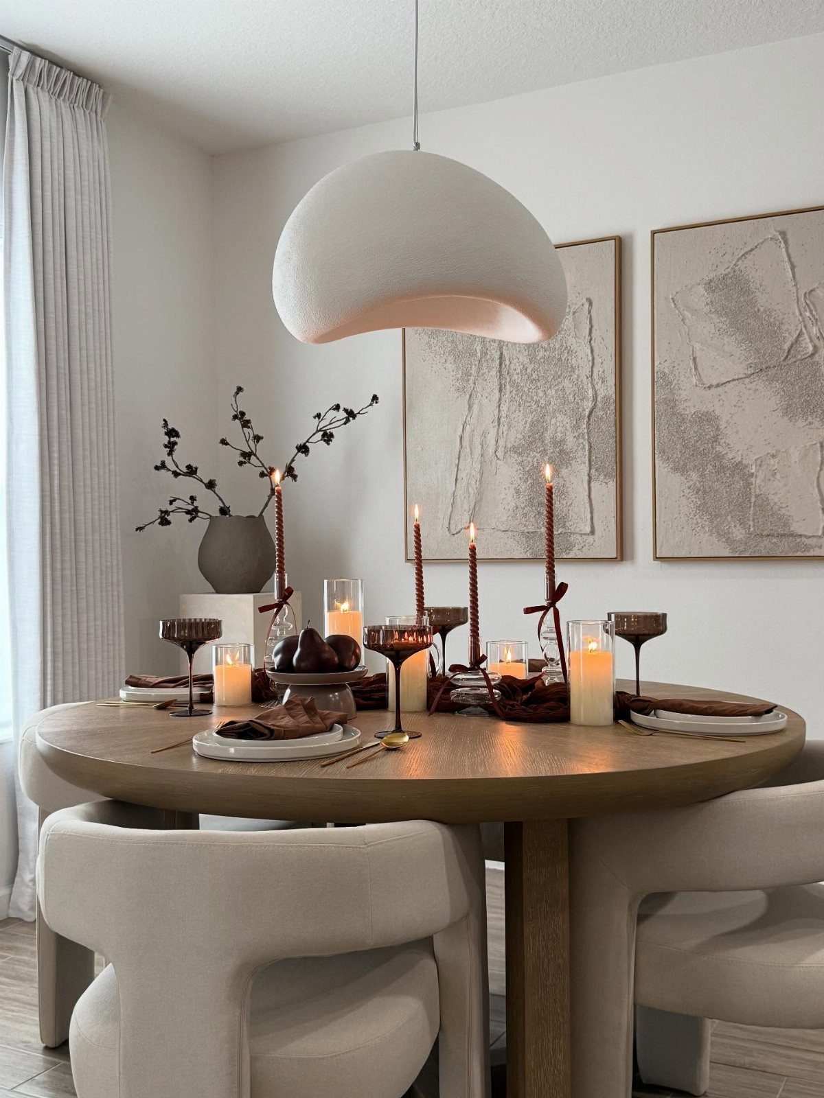 Brown monochromatic dining table setting with candles, pumpkins, and elegant brown dinnerware.
