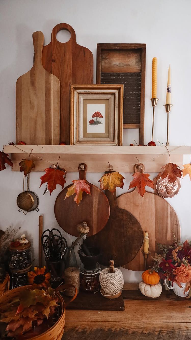 Fall fireplace mantel decorated with wooden boards, autumn leaves, and small pumpkins.
