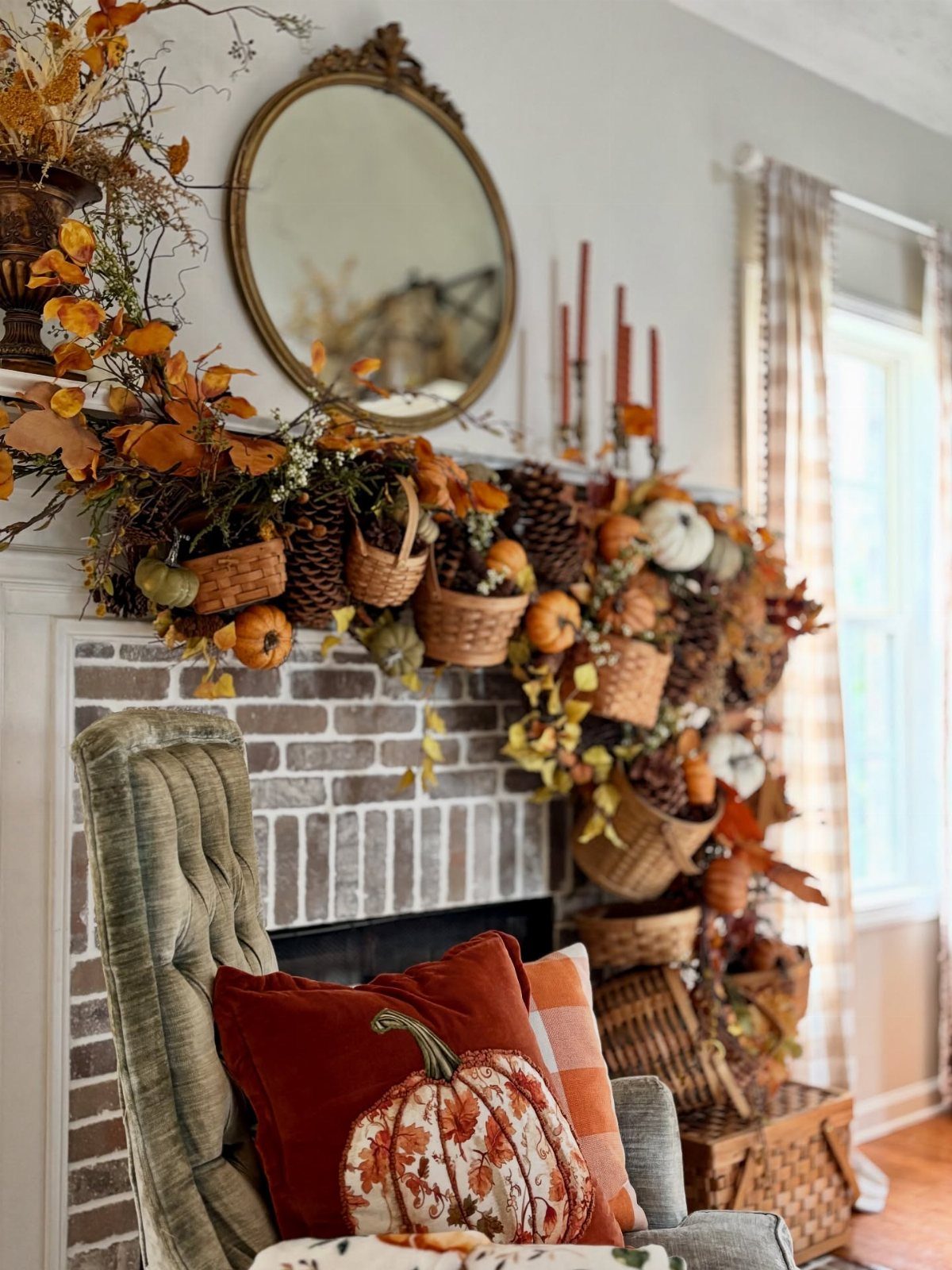 Autumn fireplace mantel decorated with orange leaves, pumpkins, and woven harvest baskets.