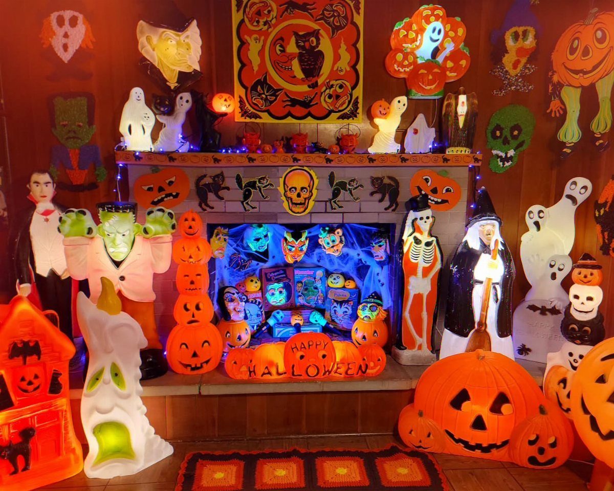 Halloween decorated fireplace with glowing orange pumpkins, ghosts, and various spooky characters.