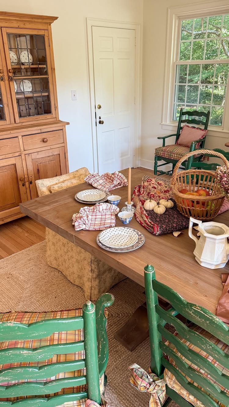 Rustic wooden harvest table set with fruit and dishes in a farmhouse dining room