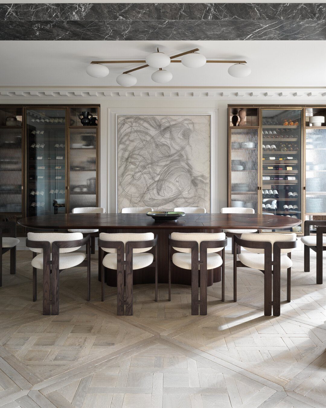 Formal dining room with dark wood table, white chairs, and modern globe lighting.