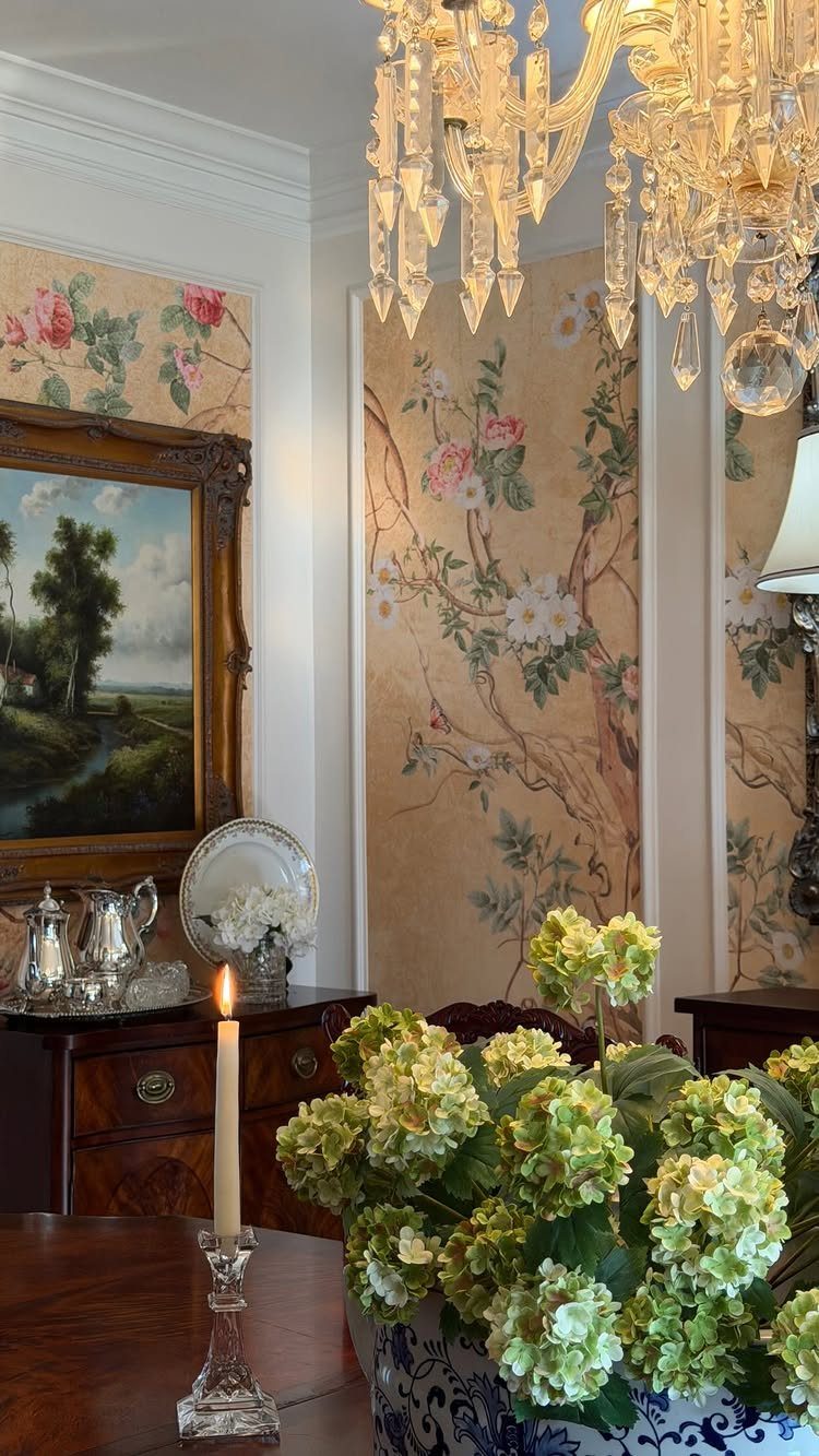 Formal dining room with floral wallpaper, crystal chandelier, and fresh green hydrangeas.