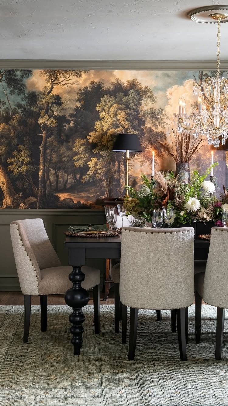 Crystal chandelier hanging over a formal dining table with beige chairs and mural.